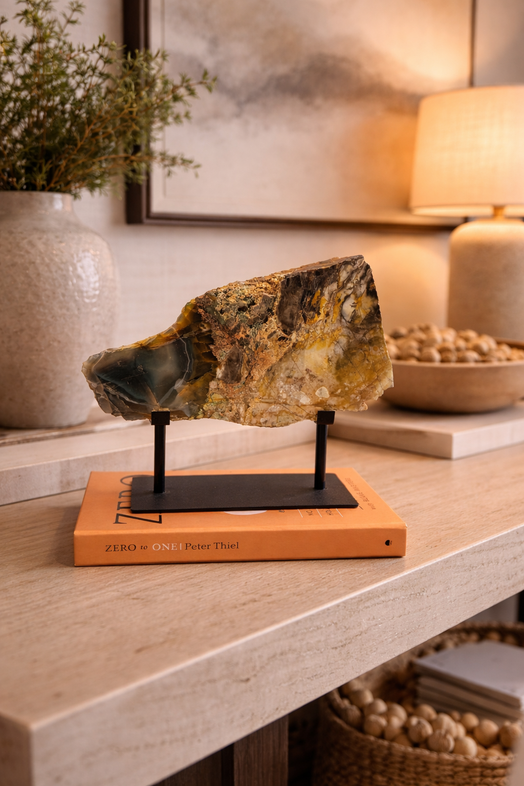 Geode on a stand on a wooden surface with decorative items in the background