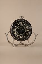 Decorative clock with antler stand on a beige background