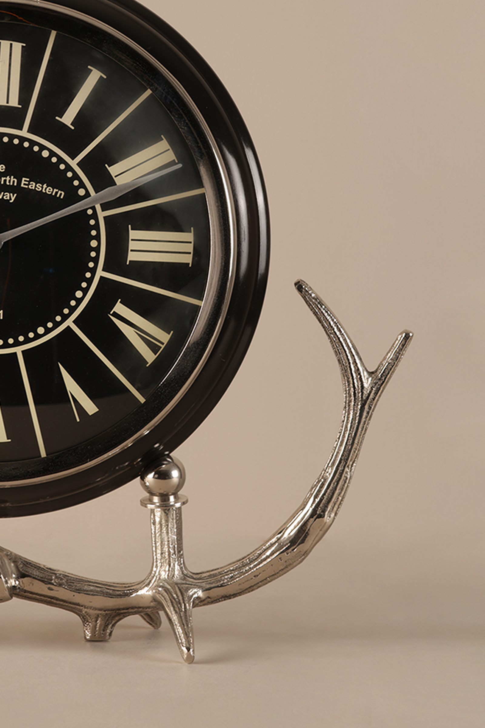 Decorative clock with antler design on a beige background