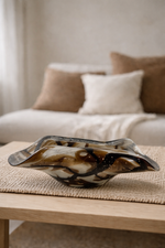 Decorative glass bowl on a wooden table with a blurred living room background