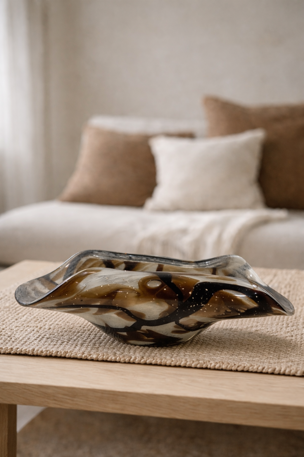 Decorative glass bowl on a wooden table with a blurred living room background
