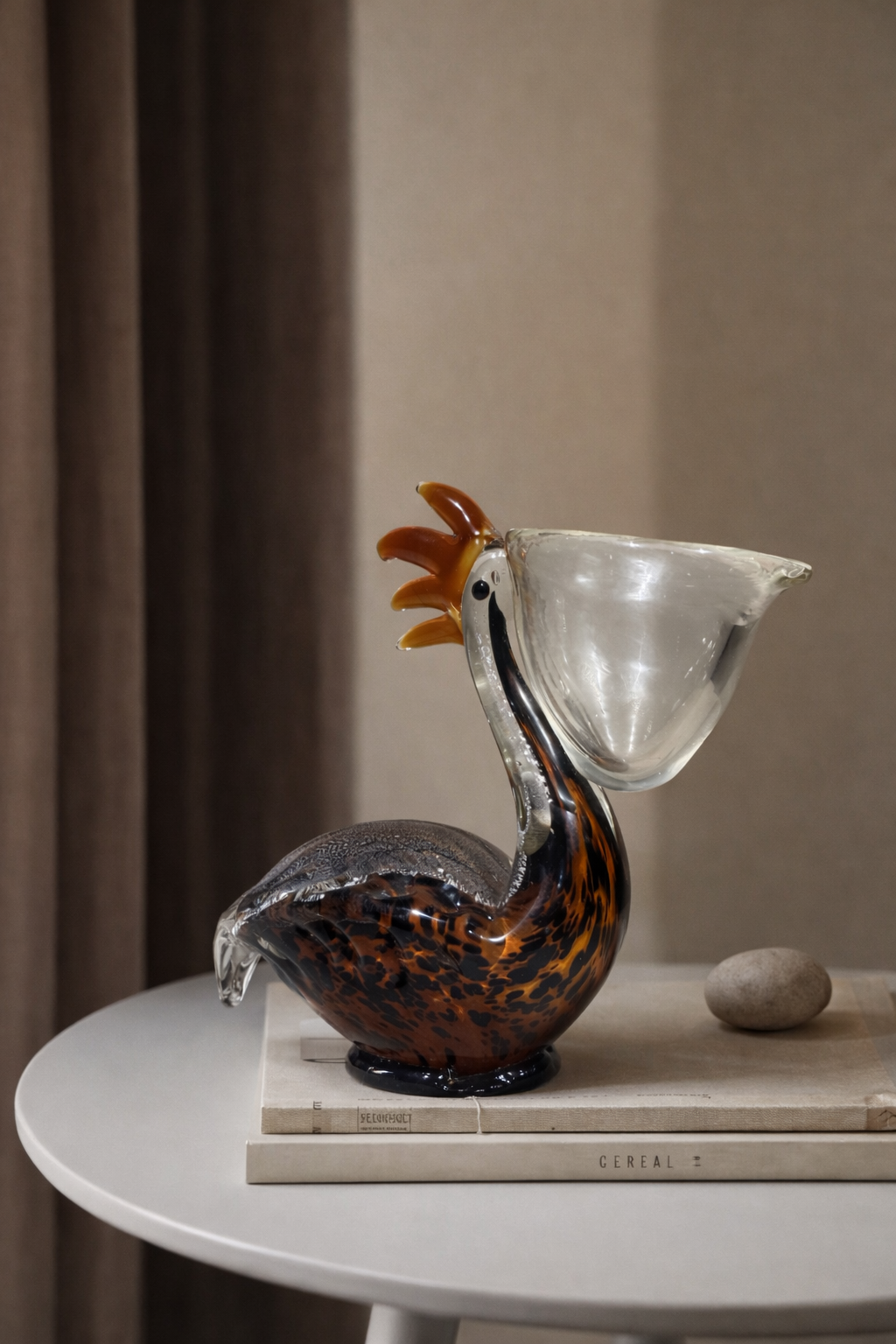 Glass rooster sculpture on a table with a neutral background