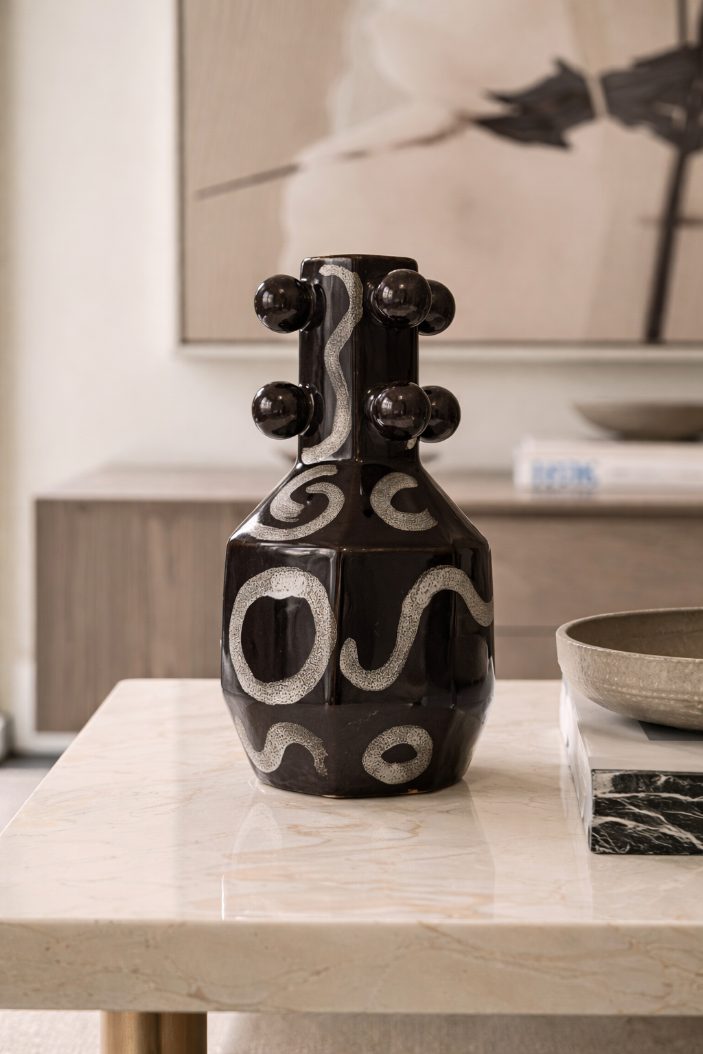Decorative black and white vase on a table with a blurred background