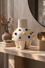 Decorative vase with colorful polka dots on a marble surface