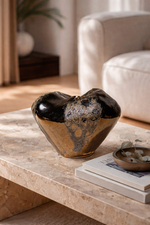 Decorative bowl on a marble surface with a blurred indoor setting