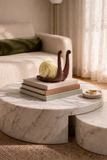 Marble coffee table with decorative items in a living room setting
