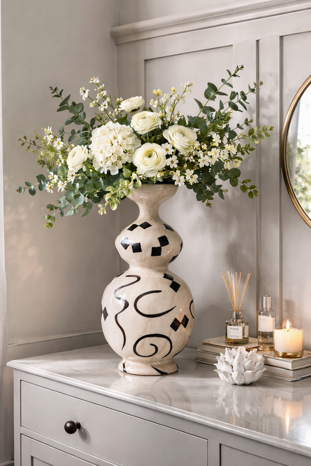 Decorative vase with flowers on a dresser against a neutral wall.