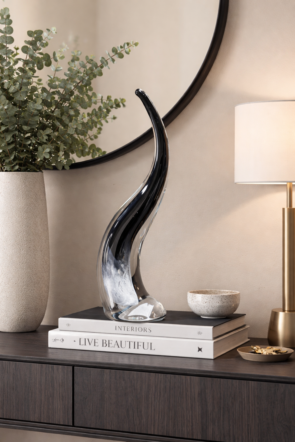 Decorative vase on a shelf with books and a lamp in a home setting