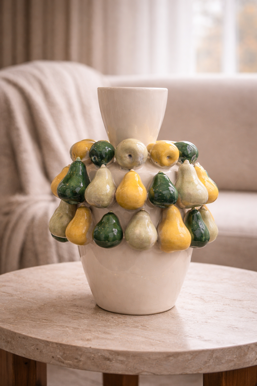 Decorative vase with pear-shaped ceramic elements on a wooden table.