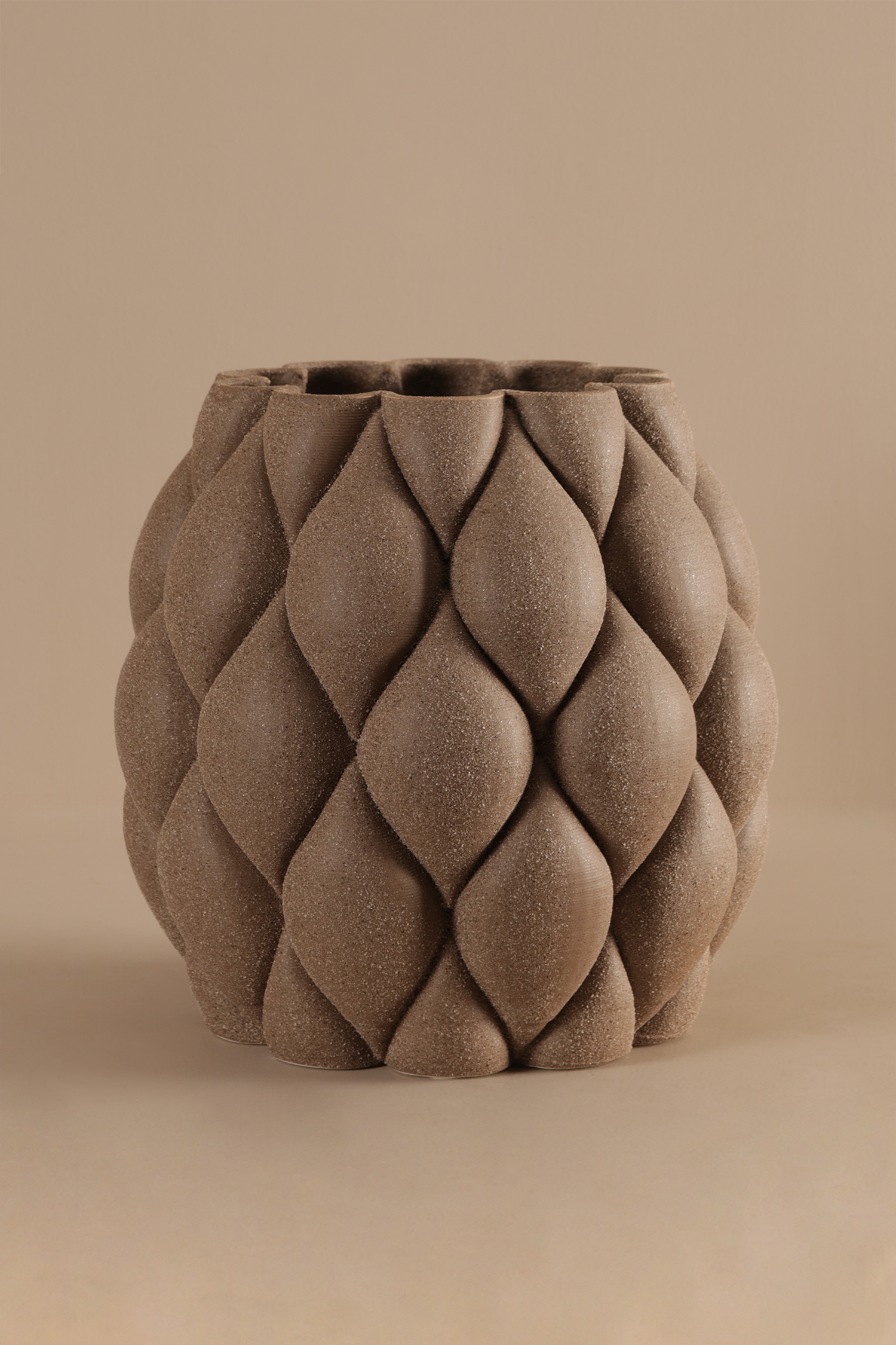 Textured brown ceramic vase on a beige background