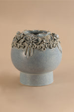 Decorative ceramic vase with floral patterns on a beige background