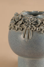 Decorative ceramic vase with floral patterns on a beige background