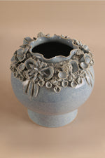 Decorative ceramic vase with floral patterns on a beige background