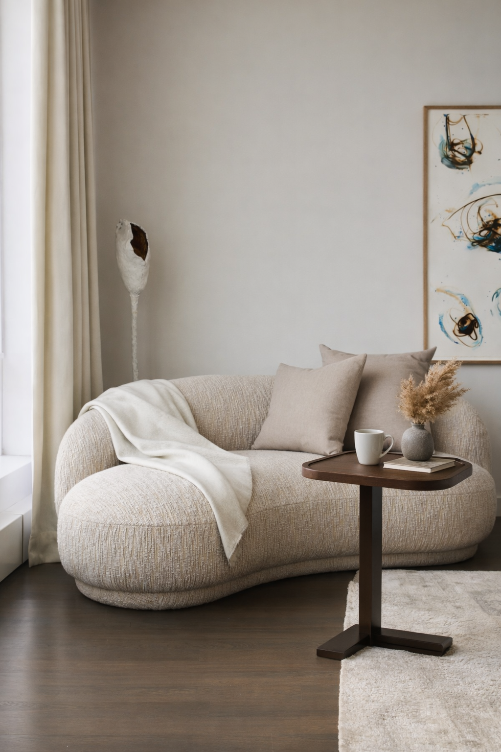 Modern living room with a beige sofa, small table, and decorative items.