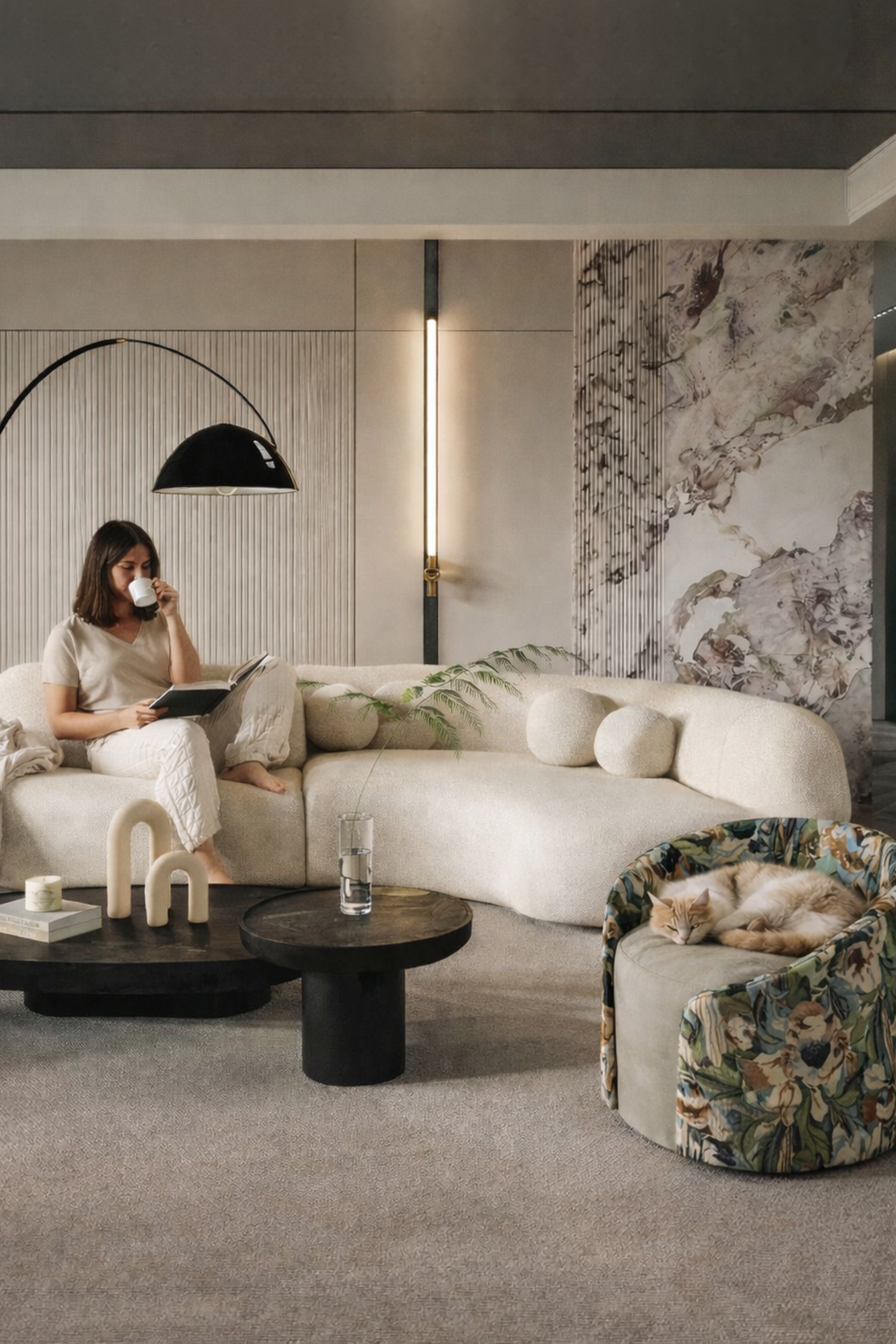 Modern living room with a woman sitting on a sofa, surrounded by stylish decor elements.
