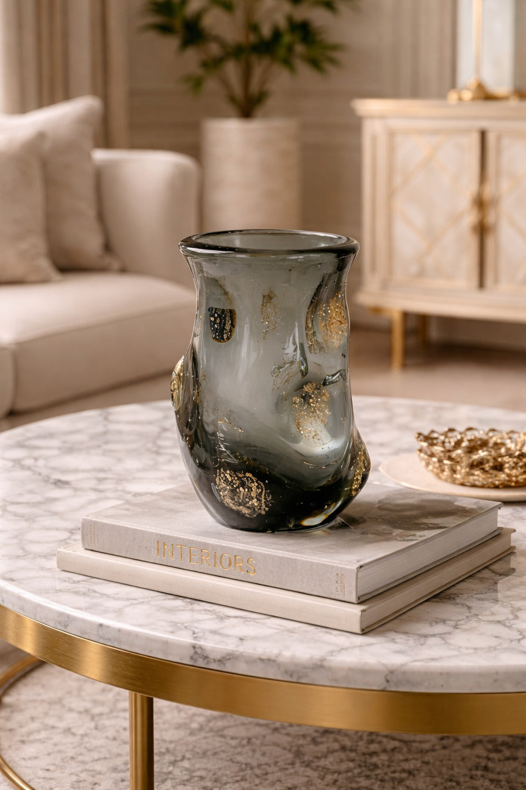 Decorative vase on books on a marble table in a living room setting