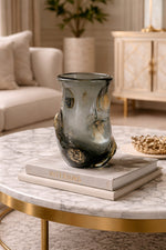 Decorative vase on books on a marble table in a living room setting